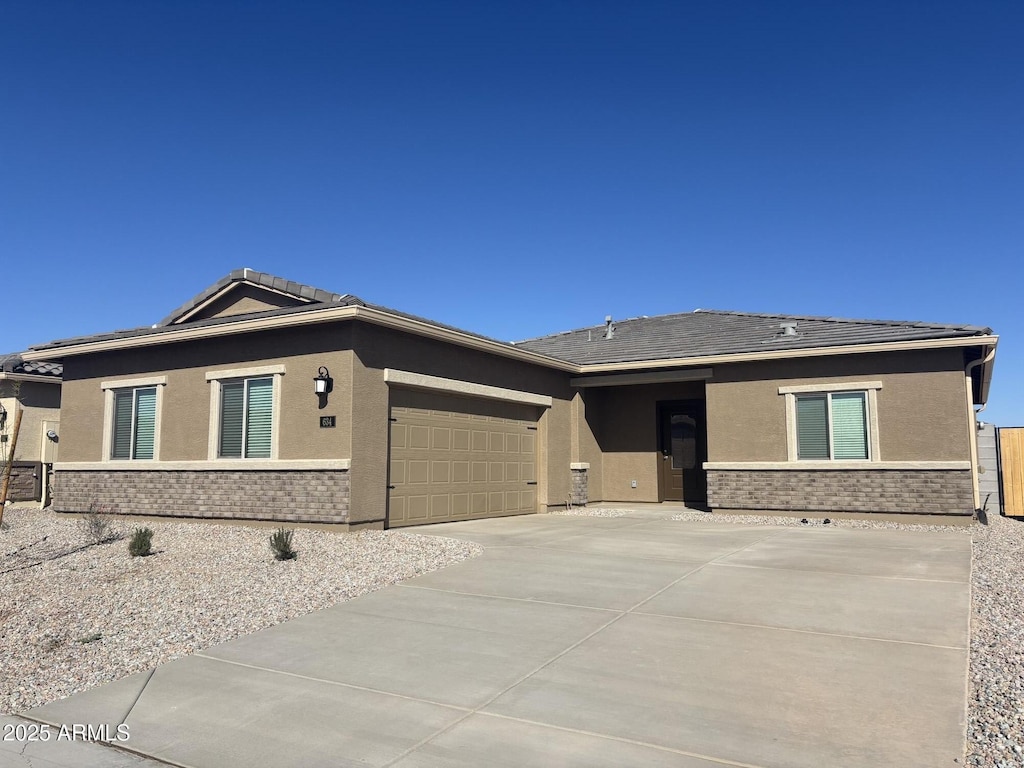 view of front of home featuring concrete driveway, an attached garage, and stucco siding