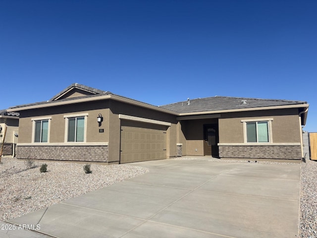 view of front of home featuring concrete driveway, an attached garage, and stucco siding