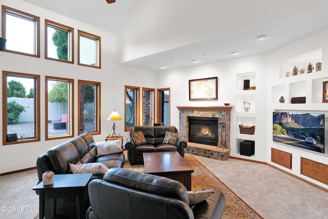 living area with high vaulted ceiling, built in features, carpet floors, a fireplace, and baseboards