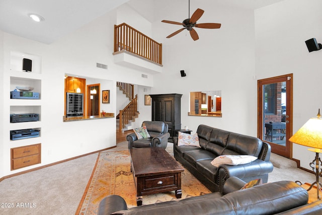 living area with visible vents, ceiling fan, baseboards, stairs, and carpet floors