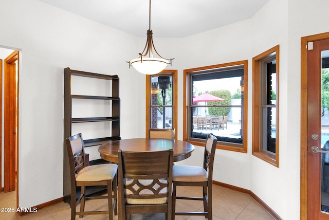 dining room with light tile patterned floors and baseboards