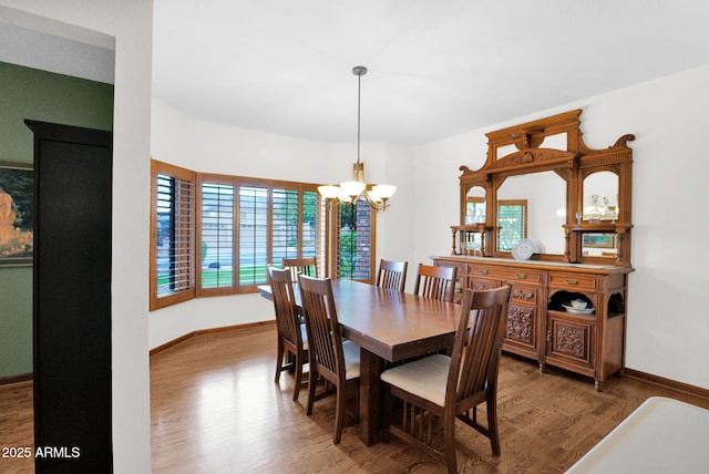 dining room with baseboards, an inviting chandelier, and wood finished floors