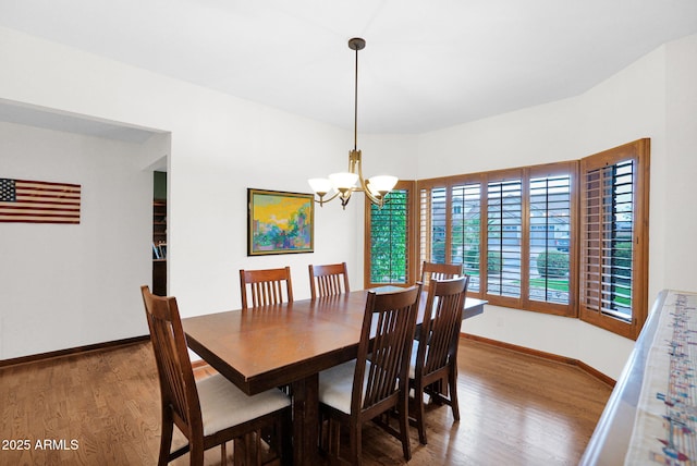 dining room with baseboards, an inviting chandelier, and wood finished floors