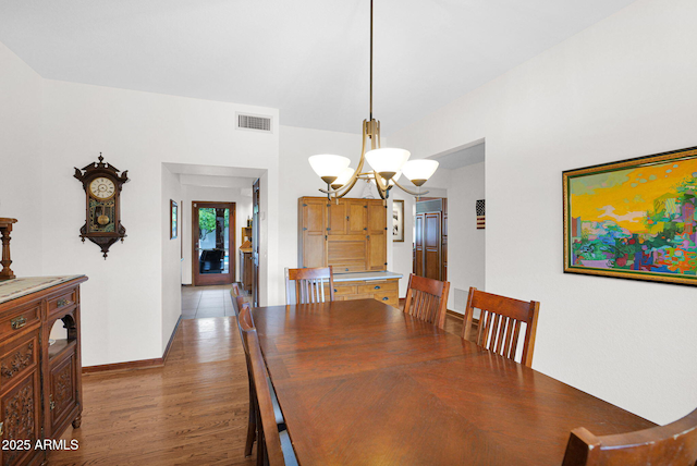 dining area featuring visible vents, baseboards, a notable chandelier, and wood finished floors