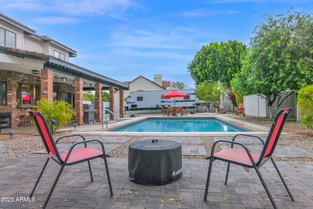 view of swimming pool featuring grilling area, a fenced in pool, and a patio