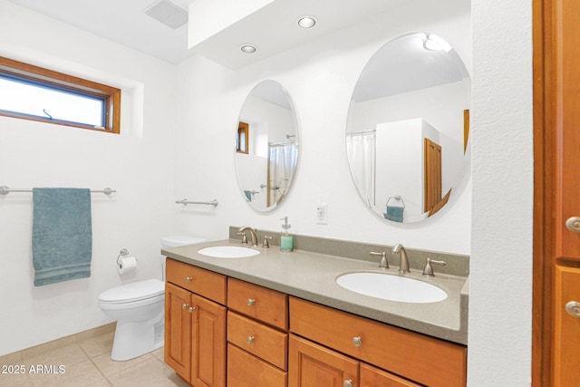 full bath featuring a sink, toilet, double vanity, and tile patterned flooring