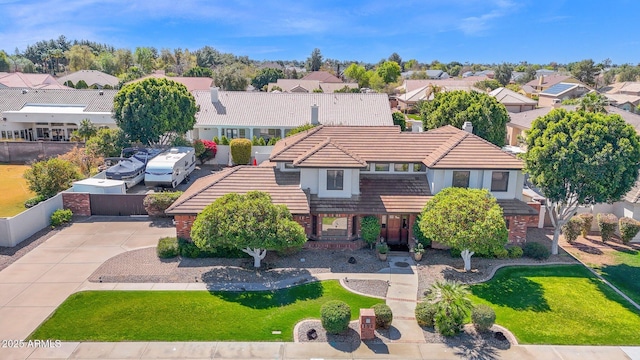 view of front of house featuring a residential view, a tile roof, and fence