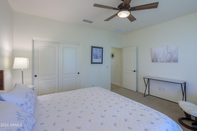 carpeted bedroom featuring a closet and ceiling fan