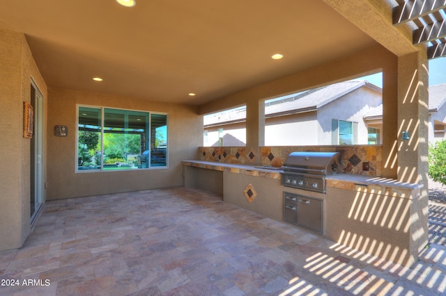 view of terrace featuring exterior kitchen and a grill