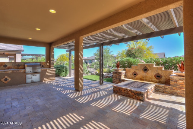 view of terrace with a pergola, a grill, and exterior kitchen