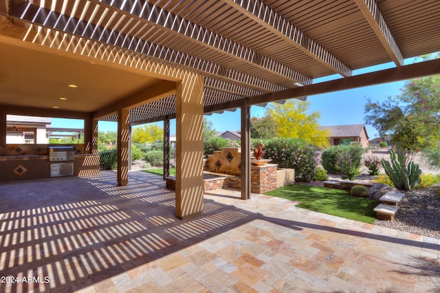 view of terrace featuring exterior kitchen, a grill, and a pergola