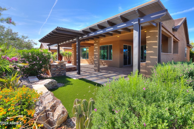 back of property with a patio area, a yard, and a pergola