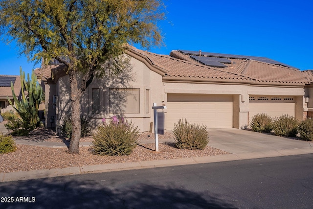 view of front of property featuring a garage and solar panels