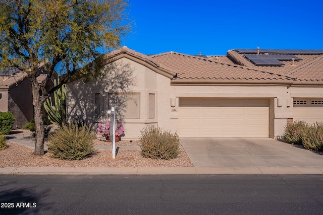 view of front of property with a garage and solar panels