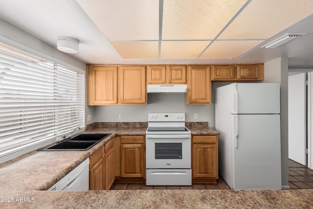 kitchen with tile patterned flooring, visible vents, under cabinet range hood, white appliances, and a sink