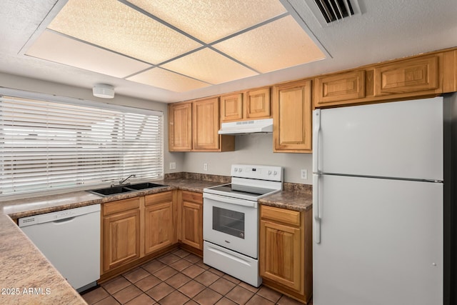 kitchen with visible vents, under cabinet range hood, tile patterned floors, white appliances, and a sink