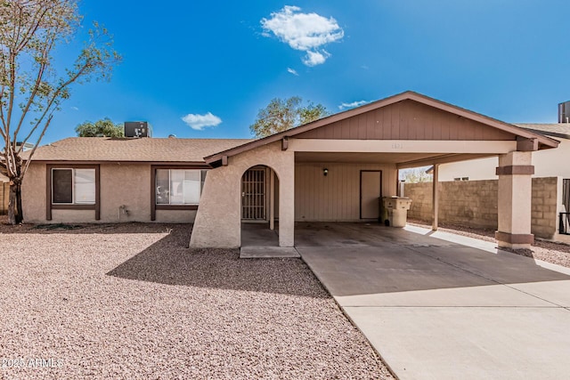 ranch-style house featuring fence, roof with shingles, stucco siding, cooling unit, and driveway