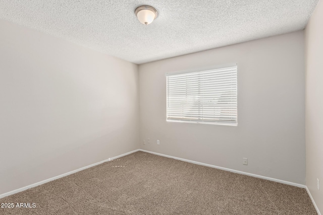 carpeted spare room featuring baseboards and a textured ceiling