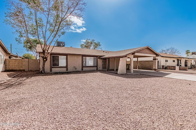 ranch-style house featuring stucco siding, central AC, and fence