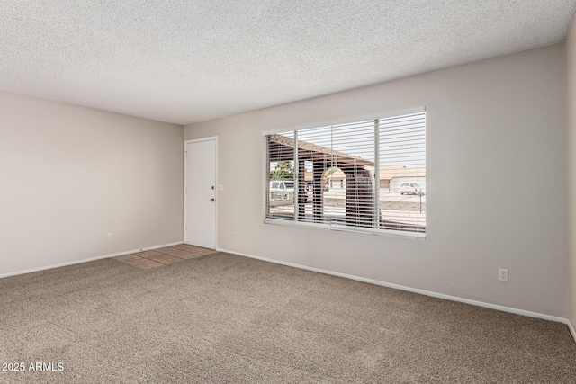 spare room with baseboards, a textured ceiling, and carpet