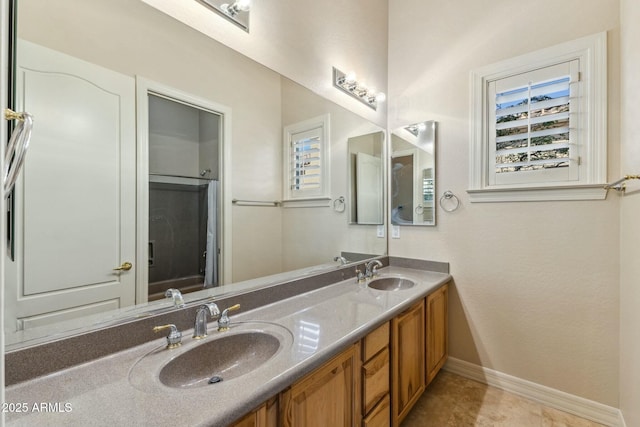 bathroom with double vanity, tile patterned flooring, baseboards, and a sink