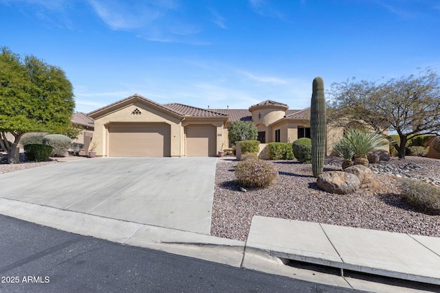 view of front of property with an attached garage, a tile roof, concrete driveway, and stucco siding