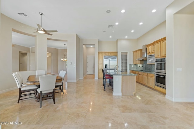 kitchen with tasteful backsplash, visible vents, a breakfast bar area, appliances with stainless steel finishes, and a sink