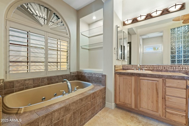 full bathroom with a jetted tub, vanity, and tile patterned floors