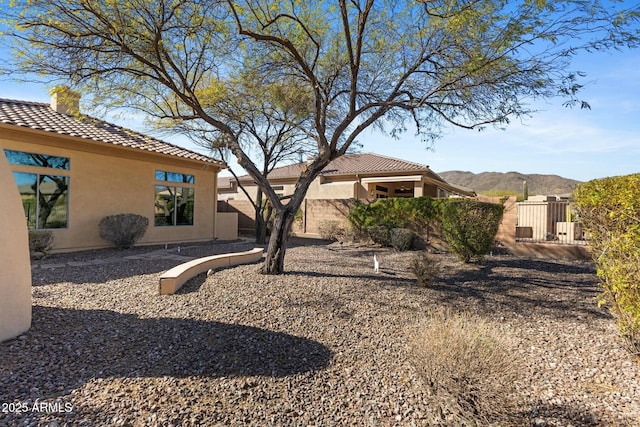 view of yard featuring a gate, fence, and a mountain view