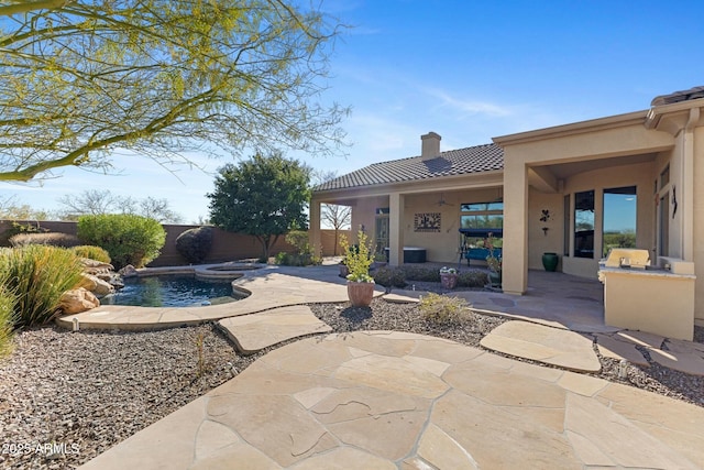 view of swimming pool with a fenced backyard, a fenced in pool, exterior kitchen, and a patio