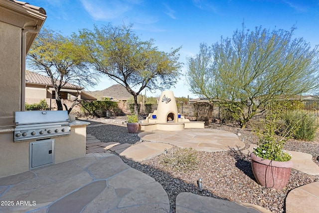 view of patio with exterior fireplace, grilling area, area for grilling, and a fenced backyard