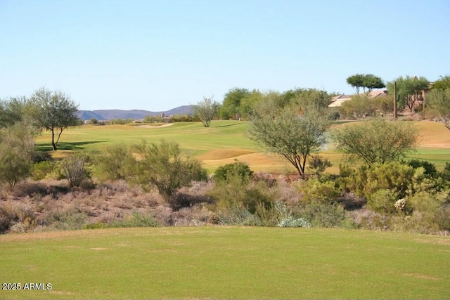 surrounding community with a mountain view and a lawn