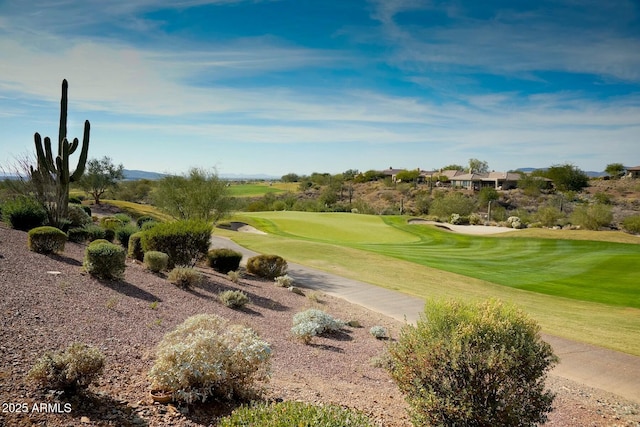 surrounding community with view of golf course and a lawn