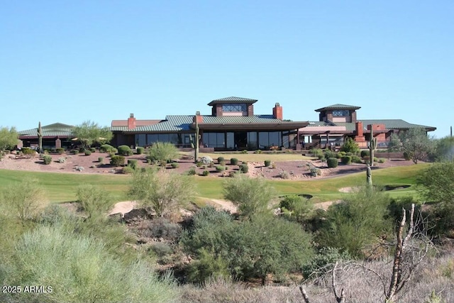 rear view of house featuring a yard and a chimney