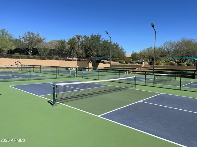 view of tennis court featuring fence and a mountain view