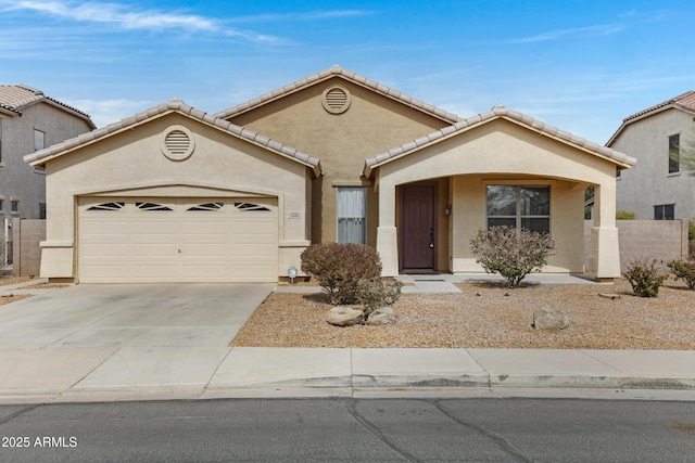 view of front of home featuring a garage, concrete driveway, a tile roof, and stucco siding