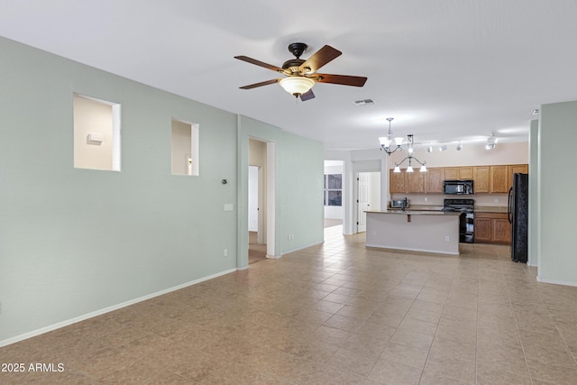 unfurnished living room with ceiling fan with notable chandelier, visible vents, and baseboards