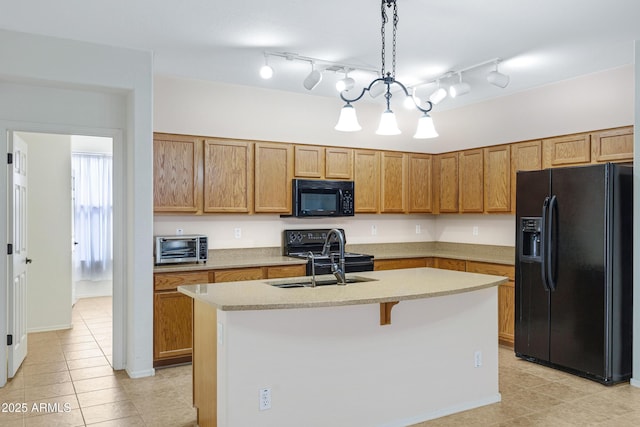 kitchen featuring black appliances, a kitchen island with sink, light countertops, and a sink