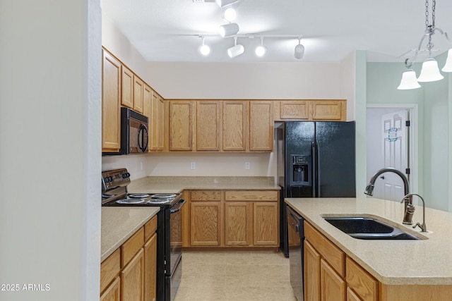 kitchen with pendant lighting, a sink, an island with sink, and black appliances