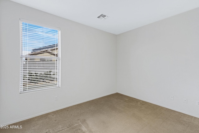 carpeted empty room with visible vents and baseboards