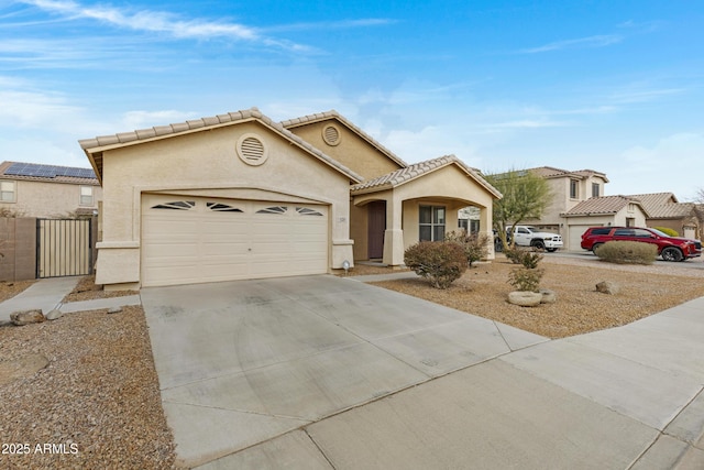 mediterranean / spanish house featuring a garage, concrete driveway, a tile roof, and stucco siding