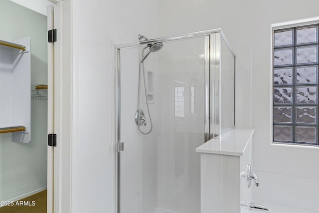 bathroom featuring a shower stall and a spacious closet