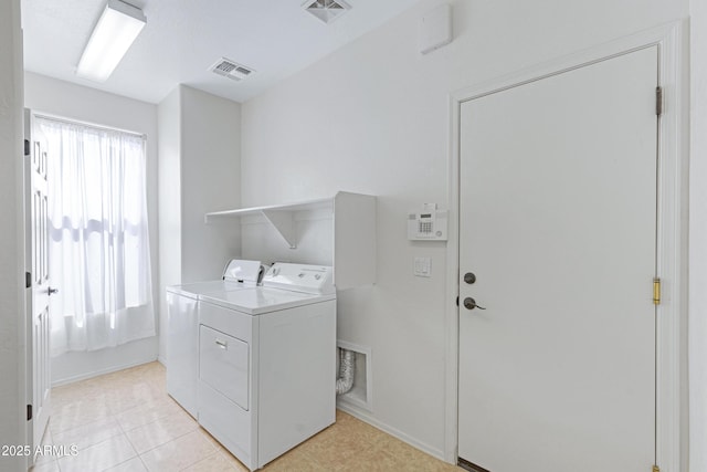 washroom featuring laundry area, washer and clothes dryer, visible vents, and a healthy amount of sunlight