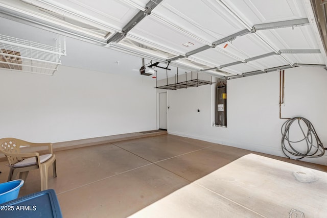 garage featuring baseboards, electric water heater, and a garage door opener