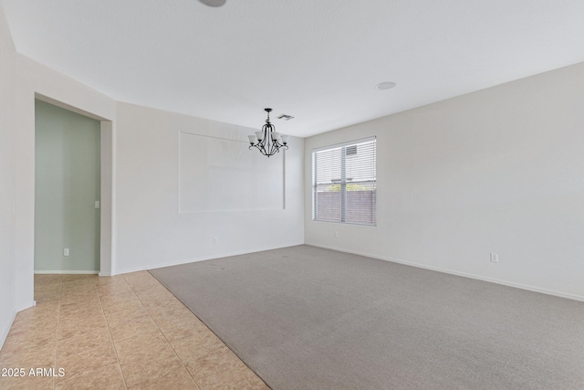 carpeted spare room with a chandelier, tile patterned flooring, visible vents, and baseboards