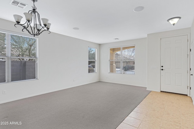 foyer featuring a notable chandelier, visible vents, carpet flooring, baseboards, and tile patterned floors