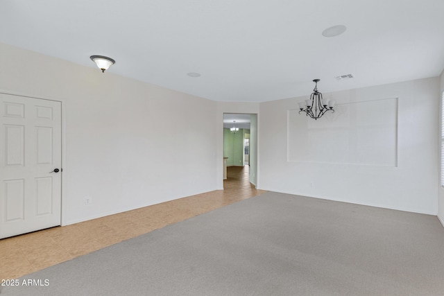 carpeted empty room featuring visible vents and an inviting chandelier