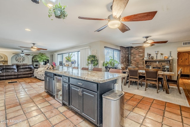 kitchen featuring a kitchen island, a wood stove, and wine cooler