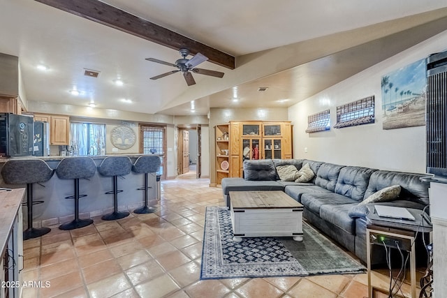 living room featuring ceiling fan and vaulted ceiling with beams