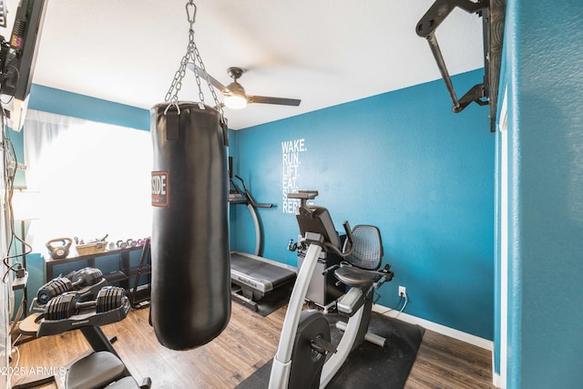 exercise room with baseboards and wood finished floors